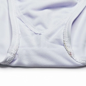 Macro detail of breathable mesh fabric and double-stitched seams on white swimwear