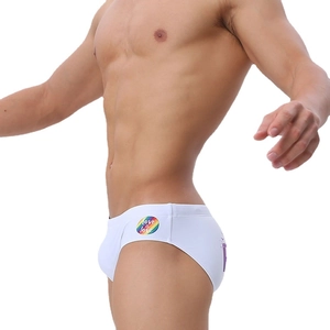 Close-up of white low-rise men's swim briefs featuring a rainbow Love is Love print design
