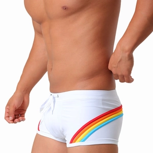 Close-up of white swim trunks featuring rainbow side stripes and a drawstring waistband