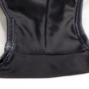 Detailed close-up of premium black elastic fabric with precise reinforced double stitching
