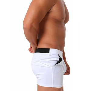 Detail view of men's white cotton shorts featuring a black elastic waistband and zip pocket