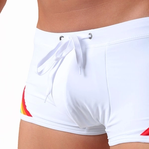 Detail of white men's swim trunks featuring rainbow side stripes and adjustable drawstring