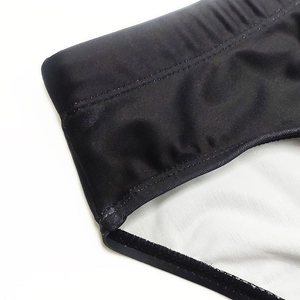 Close-up of men's quick-dry black swim trunks showing elastic waistband and fine stitching