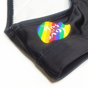 Detailed close-up of rainbow heart print with love is love slogan on black swim briefs