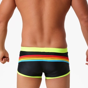 Rear view of men's black swim trunks featuring rainbow stripes and neon yellow trim