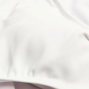 Macro view of white swim briefs fabric showing smooth texture and high-quality stitching