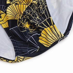 Close-up of quick-dry swim briefs showing yellow fan print and high-quality side stitching