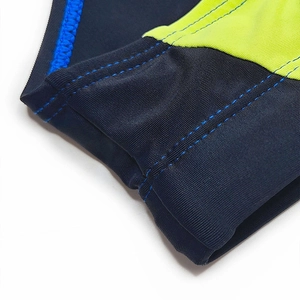 Detail of blue and lime green color-block swim briefs with reinforced stitching