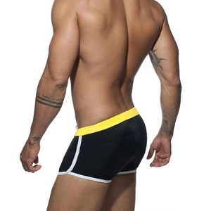 Rear view of men's black and yellow color-block swim trunks with white piping trim