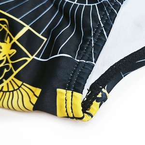 Macro shot of high-elastic men's swim trunks featuring precise stitching and black gold print