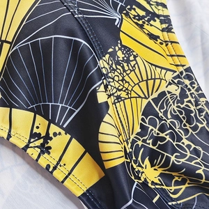 Detailed close-up of quick-dry swim briefs showing fan print and durable double stitching