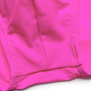 Macro view of rose red quick-dry swimwear fabric with double-needle stitching detail