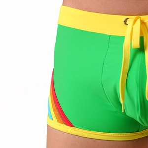 Close-up of bright green swim trunks featuring rainbow stripes and yellow drawstrings