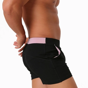 Detail view of men's slim cotton shorts featuring pink contrast pockets and waistband