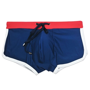 Detail view of navy men's swim trunks with red waistband and white side piping details
