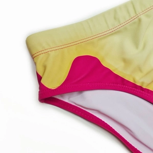 Detail of men's swim briefs showing vibrant yellow and pink wave pattern with white lining