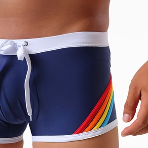 Detail of blue swim trunks with rainbow side stripes and white elastic waistband