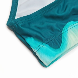Macro shot of gradient print swim briefs showing premium double-stitched elastic fabric