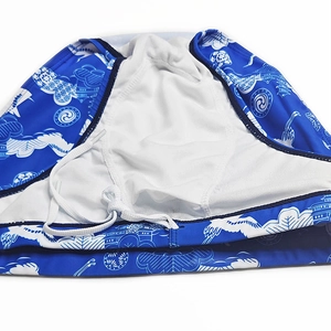 Détail du maillot de bain homme avec motif grue, doublure en filet et cordon blanc