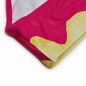 Detail view showing professional flatlock stitching on pink and yellow swim trunks