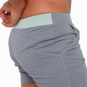 Detail of men's cotton shorts showing contrast green waistband and side pocket stitching