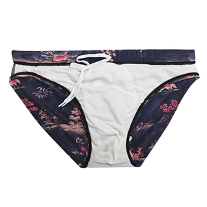 Flat lay of men's swim briefs featuring floral Japanese-style prints and white drawstring