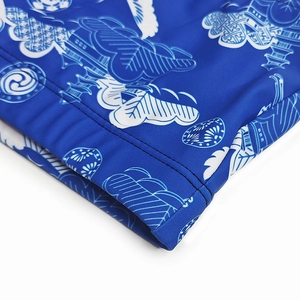 Detail of blue swim trunks featuring crane and cloud patterns with durable double-stitch seams