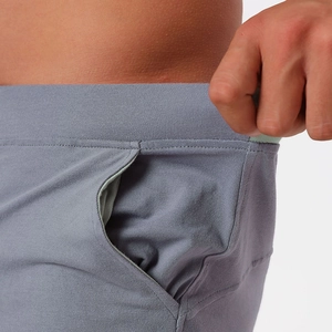 Detail of grey cotton knit shorts showing elastic waistband and side pocket texture