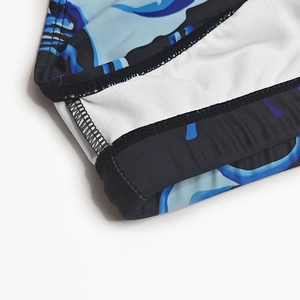 Detailed close-up of blue wave pattern swim trunks with durable double-stitch seams