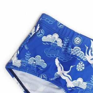 Detail of blue swim trunks featuring crane and cloud patterns in traditional style