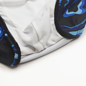 Detail of white mesh lining and blue wave print fabric on men's swim trunks