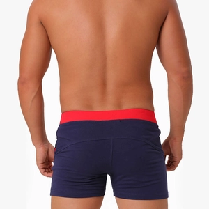 Men's slim cotton shorts featuring deep blue fabric with a red contrast waistband