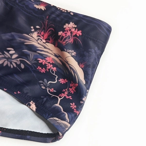 Detailed view of dark blue men's swim trunks with oriental floral print and stitching