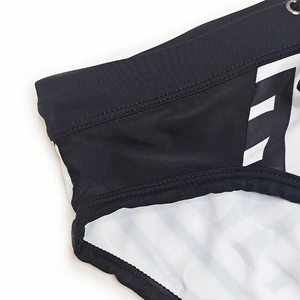 Detail of men's quick-dry swim briefs showing black and white geometric print and eyelet