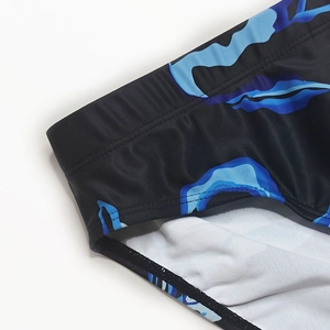Detailed view of elastic waistband and blue cloud print on men's swim trunks