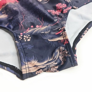 Macro detail showing high-elastic fabric stitching and Japanese floral print on swim trunks