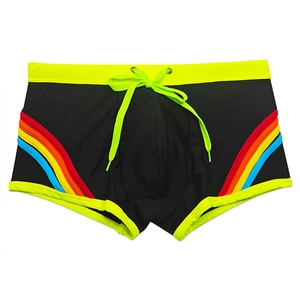 Detail of men's black swim trunks featuring rainbow side stripes and green drawstrings
