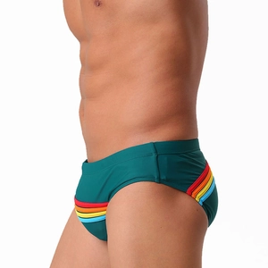 Gros plan d'un slip de bain homme vert foncé avec des bandes arc-en-ciel sur le côté