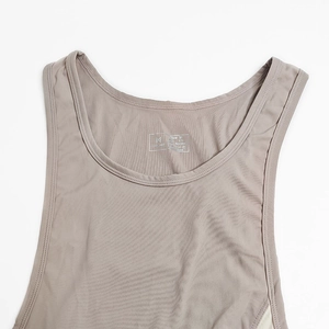Detailansicht eines grauen Nylon-Bodysuits mit M-Etikett und feiner Stoffstruktur