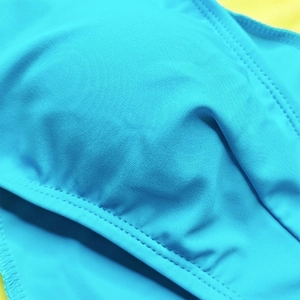 Detailed close-up of blue quick-dry swim trunks showing fine stitching and fabric texture