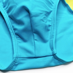 Detail view of double-stitched seams and elastic texture on sky blue men's swim briefs