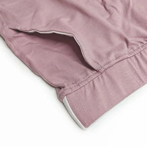 Detail of gray-pink cotton men shorts showing pocket opening and white piping trim