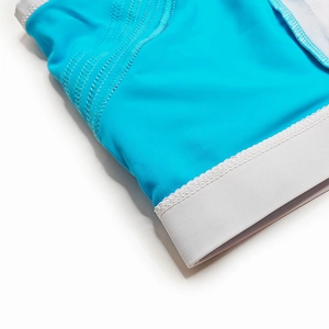 Close-up of blue swimwear with elastic waistband and decorative wavy lace trim