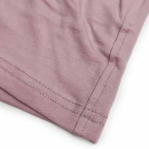 Close-up of pink cotton fabric showing fine knit texture and double-needle stitching