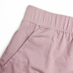 Detailed macro view of men's pink cotton lounge shorts with elastic waistband and pockets