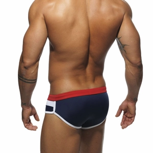Rear view of men's navy blue swimming trunks with red waistband and white piping trim