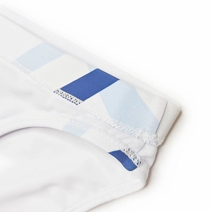 Détail du slip de bain blanc montrant la taille élastique à rayures bleues et les coutures