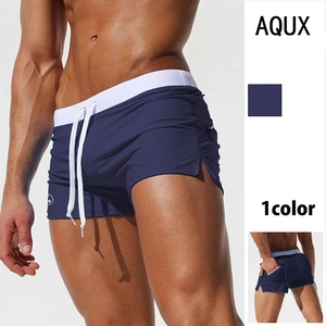 Detail of navy blue men's swim trunks featuring white drawstring waist and brand logo