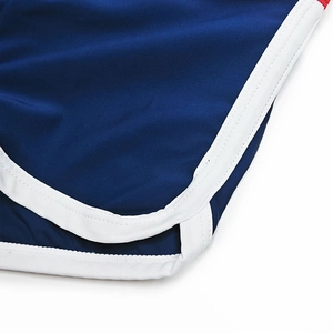 Close-up of navy blue swim trunks featuring white piping and professional double stitching