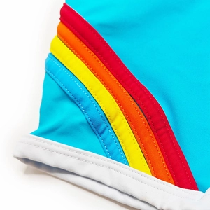 Macro detail of sky blue athletic swim trunks showing rainbow stripes and white piping